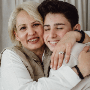 Warm hugging mother and teenage son, embracing love, family bond, emotional connection, happiness, motherhood, parent and child, heartfelt moment, close-up portrait, joyful family reunion.